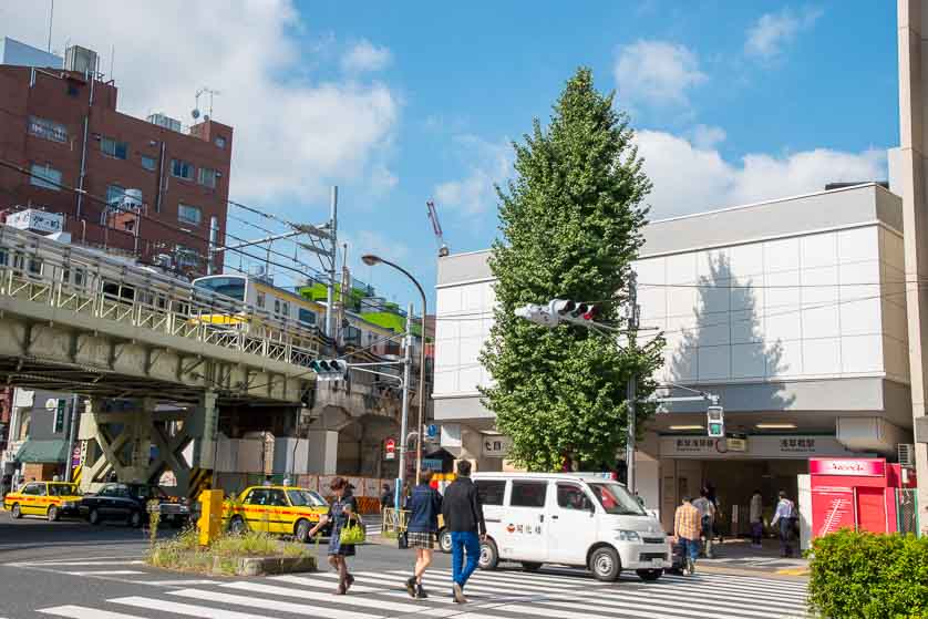 Asakusabashi Station across Edo-dori Avenue: Asakusa Subway Line Exit A3 visible at right, Sobu Line East Exit behind tree at left.