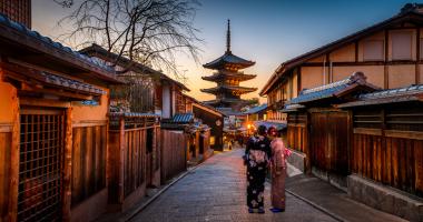 Two women in purple and pink standing on street in Gion, traditional district of Kyoto